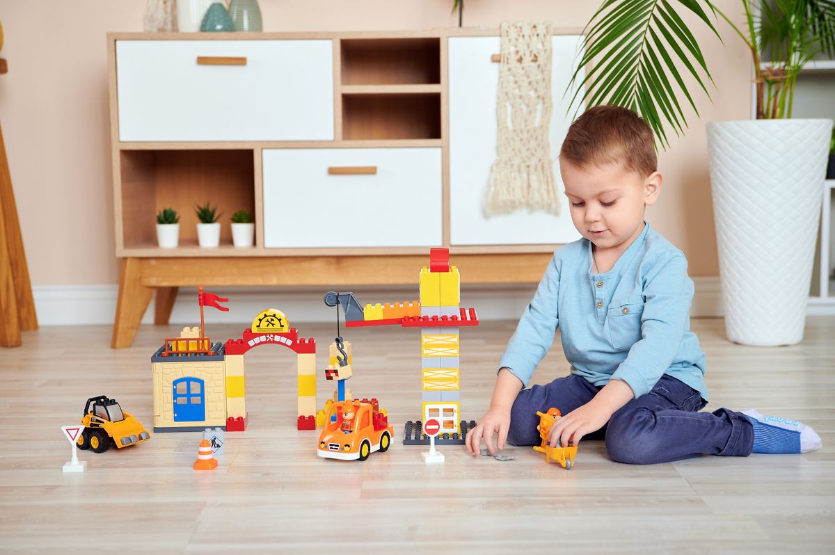 Boy sitting on the floor while playing with toys
