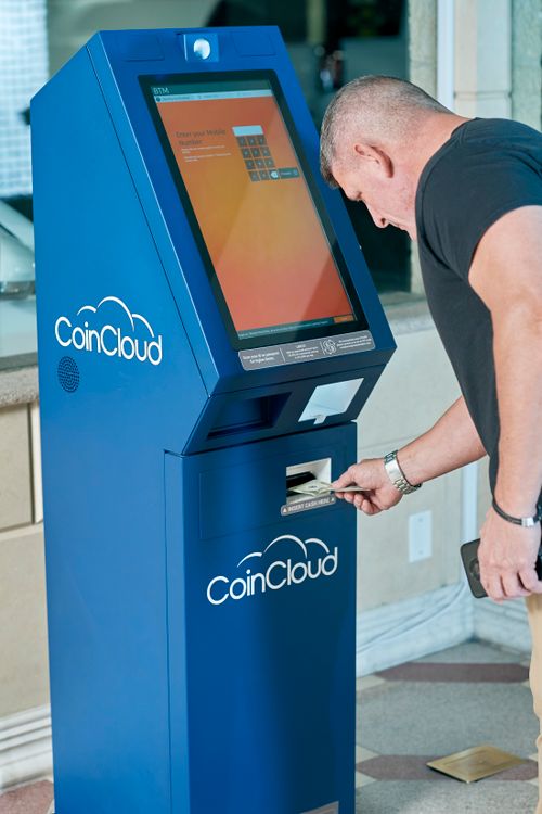 Free Adult male interacting with a Coin Cloud crypto ATM indoors, highlighting modern digital finance technology. Stock Photo