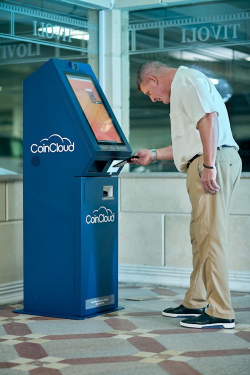 Man in White Shirt using an ATM