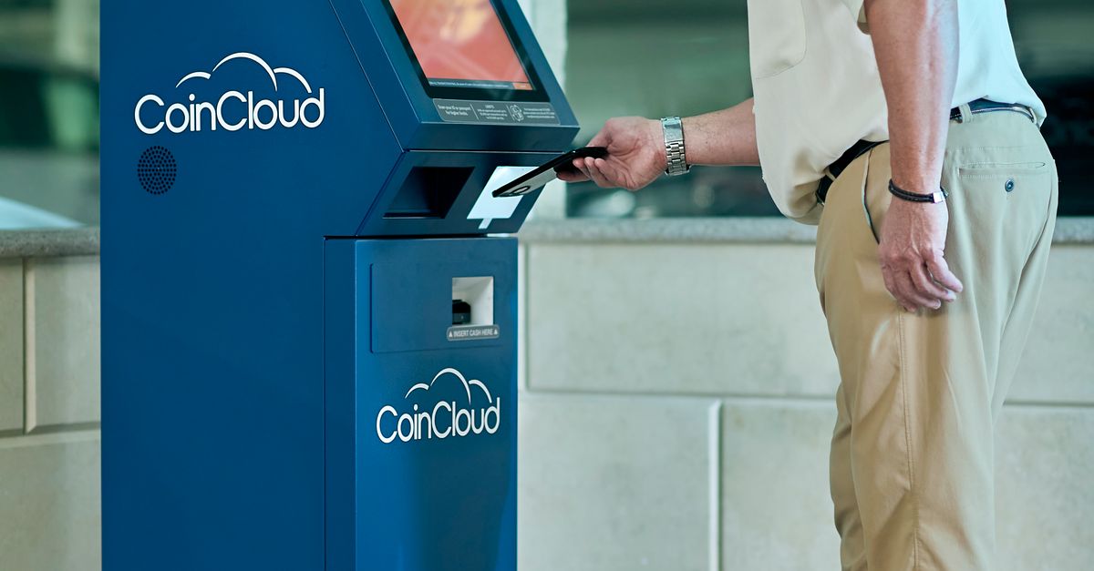 Photo by Elise Adult man transacting at a CoinCloud cryptocurrency ATM in an indoor setting.
