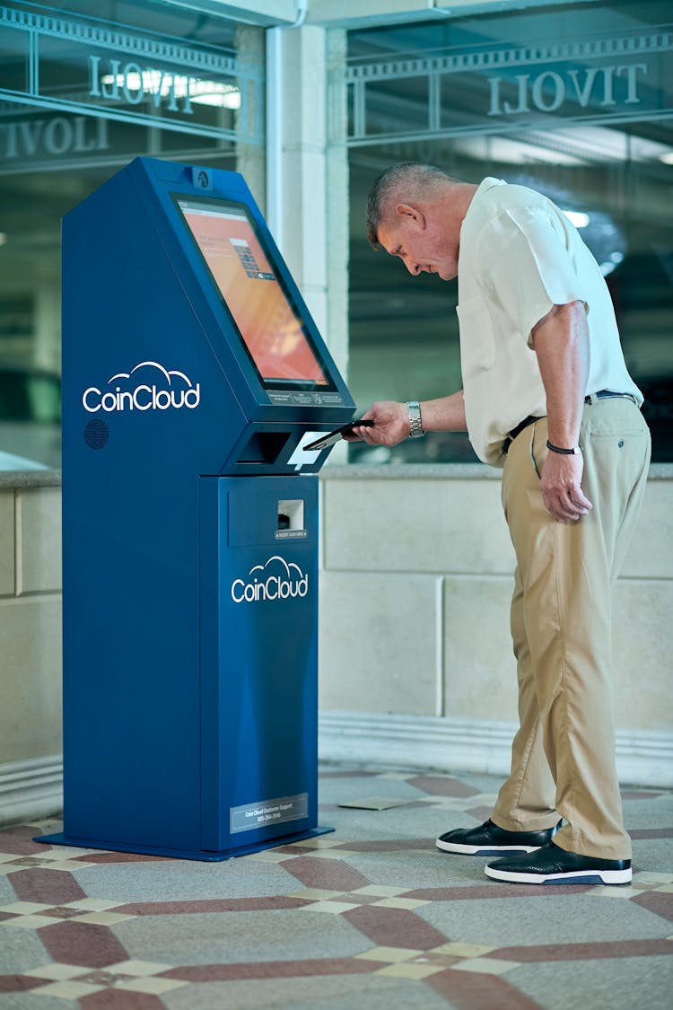 Man In White Shirt Using An ATM