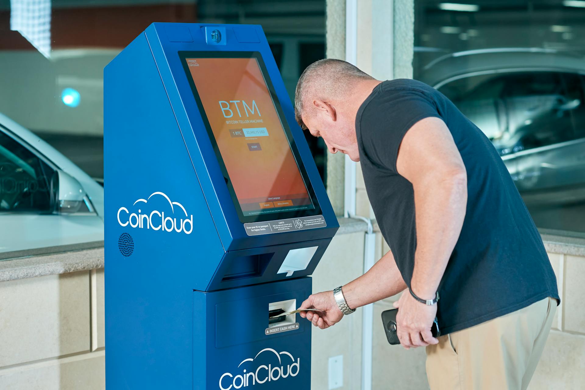 Man in Black Shirt using an ATM