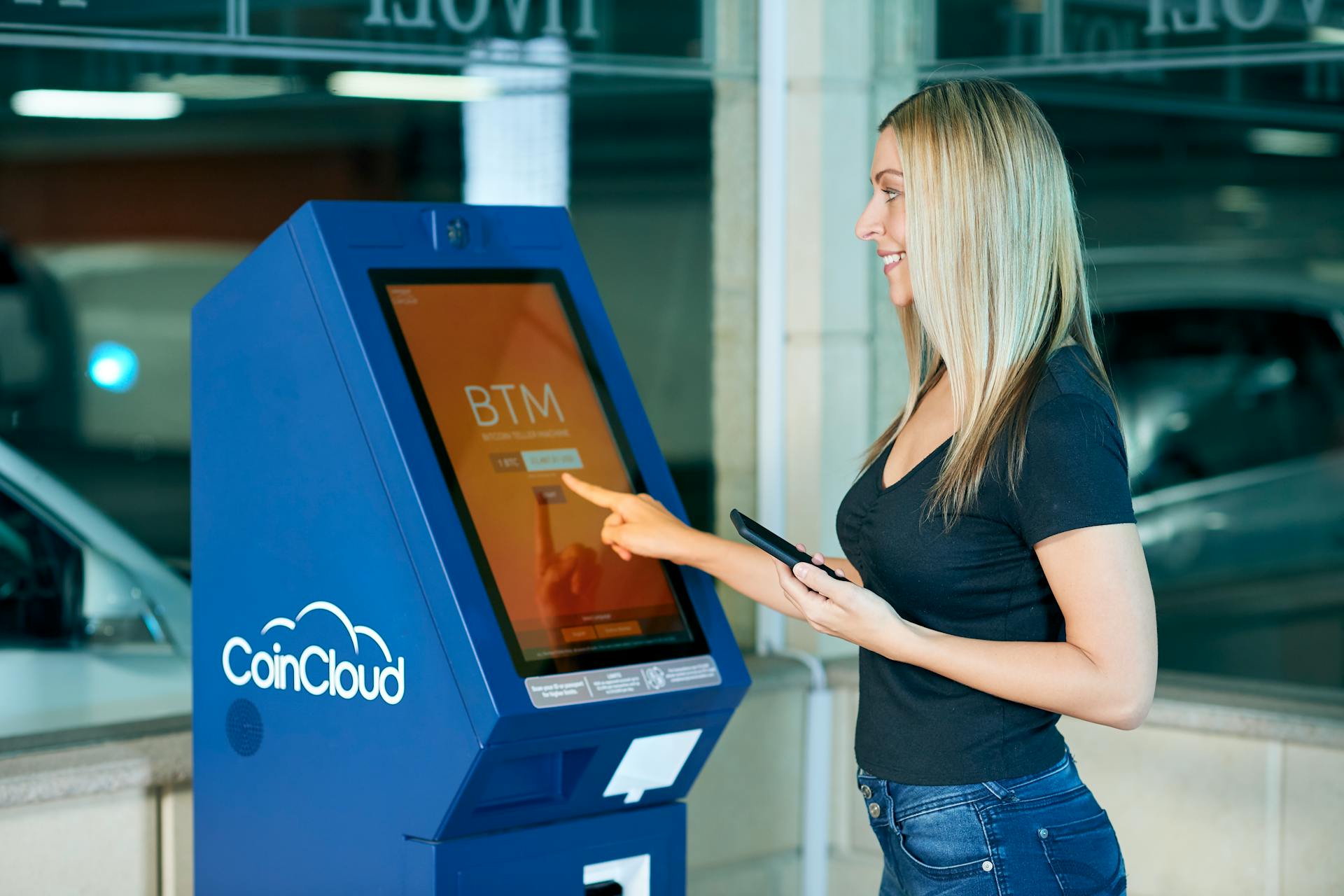 A Blonde-Haired Woman in Black Top Using ATM