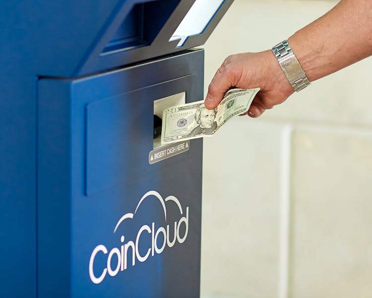 A Man Inserting Money Into A Machine