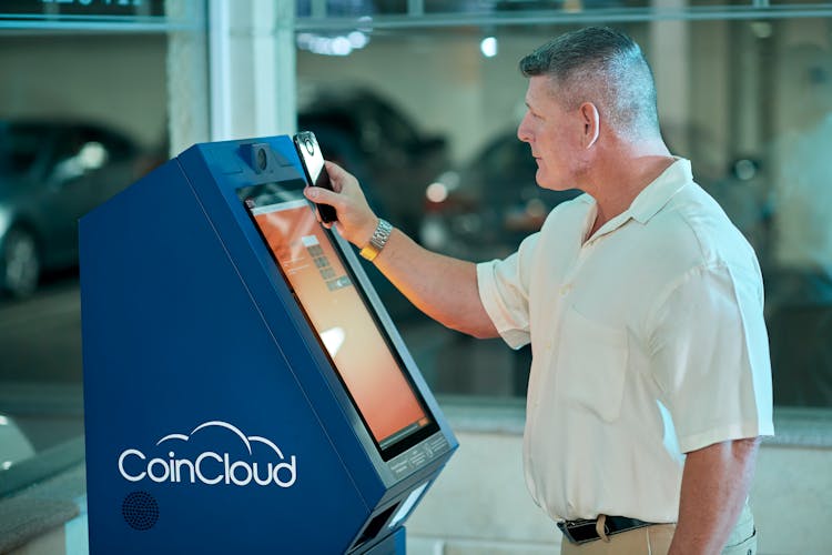 Man Using A Modern Touch Screen ATM