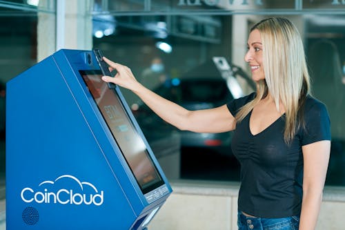 A Blonde-Haired Woman in Black Top Using ATM