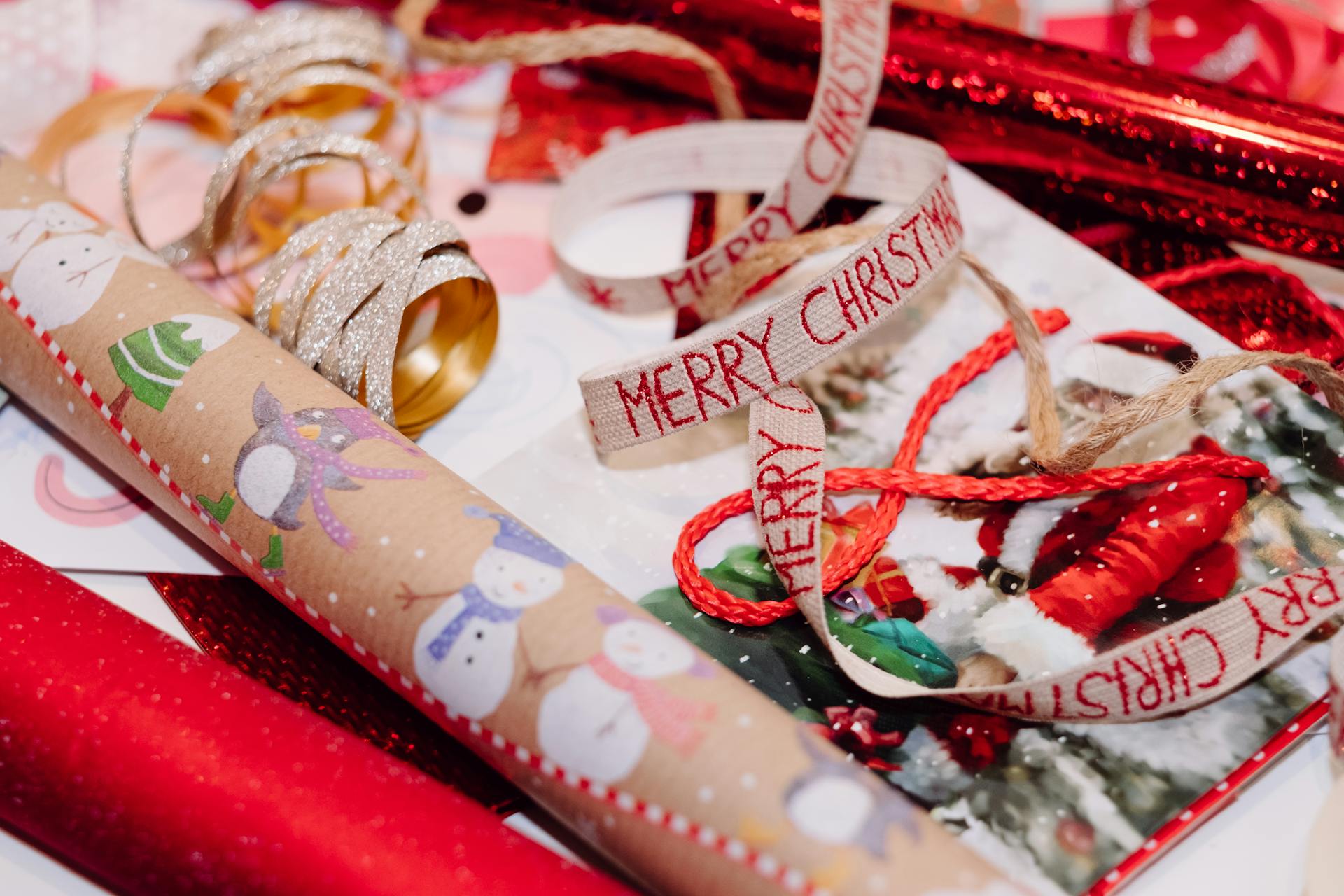 A festive assortment of Christmas wrapping paper, ribbons, and decorations, perfect for holiday gift preparations.