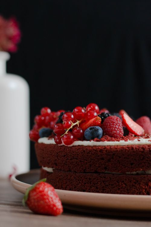 Free Tempting chocolate cake topped with assorted fresh berries, perfect for dessert lovers. Stock Photo