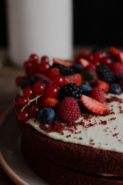 Free Scrumptious red velvet cake adorned with a variety of fresh berries, perfect for dessert lovers. Stock Photo