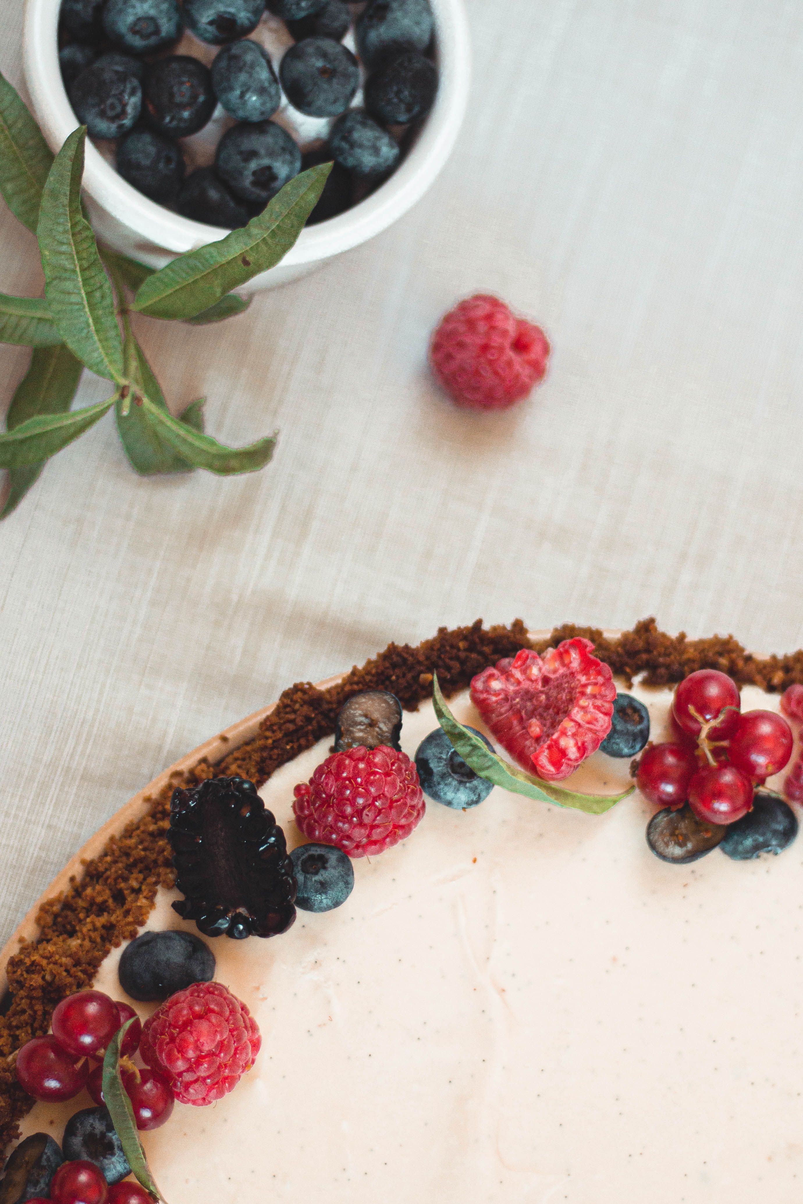 A delectable berry cheesecake featuring raspberries, blueberries, and blackberries on a rustic table.