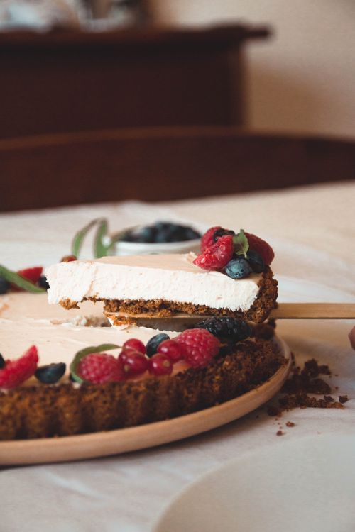 Free A slice of cheesecake with fresh berries on a graham cracker and almond crust. Stock Photo