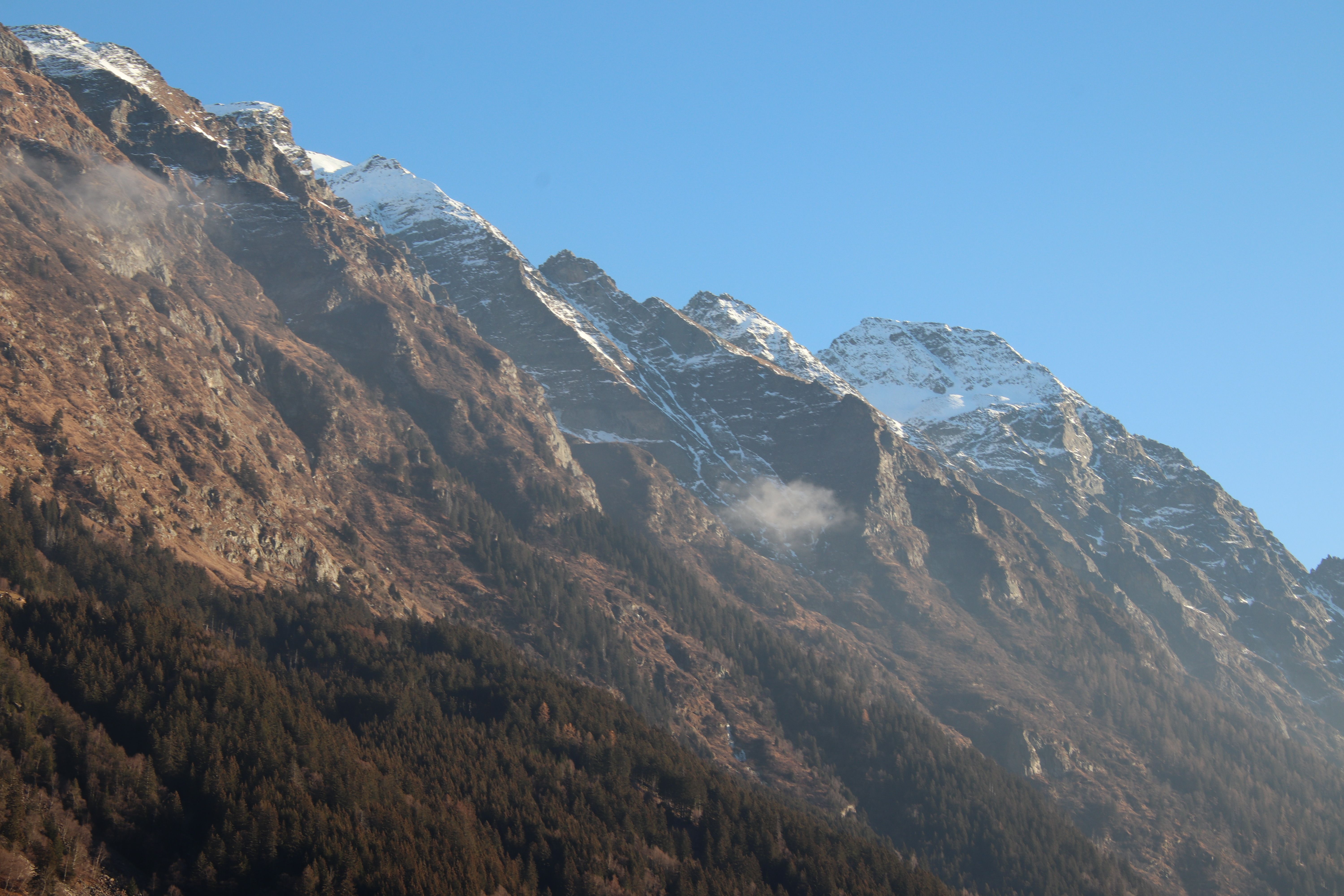 Breathtaking view of snow-capped mountains under a clear blue sky, ideal for nature photography.