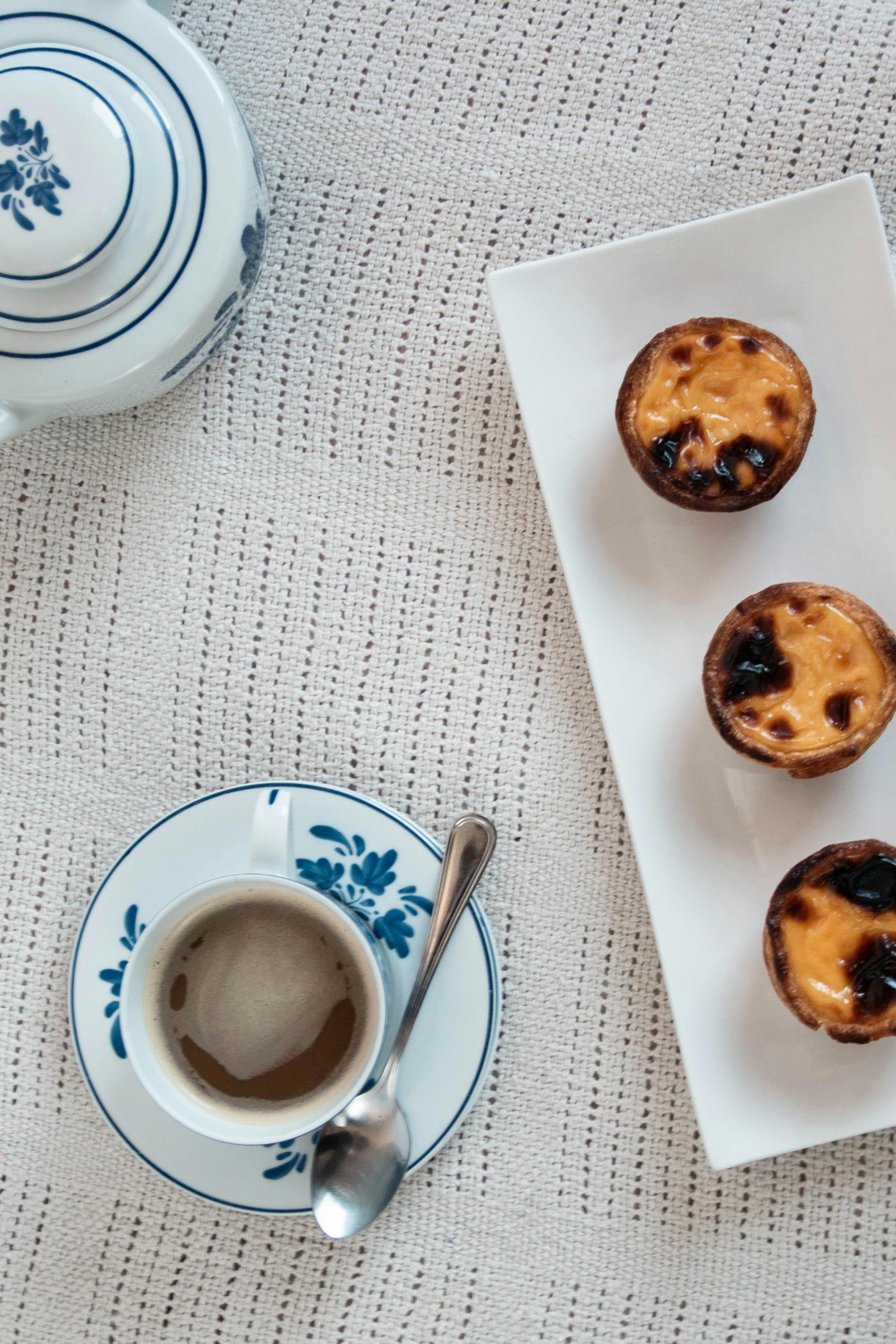 Egg Tarts on a Rectangular Plate Near a Cup of Drink · Free Stock Photo