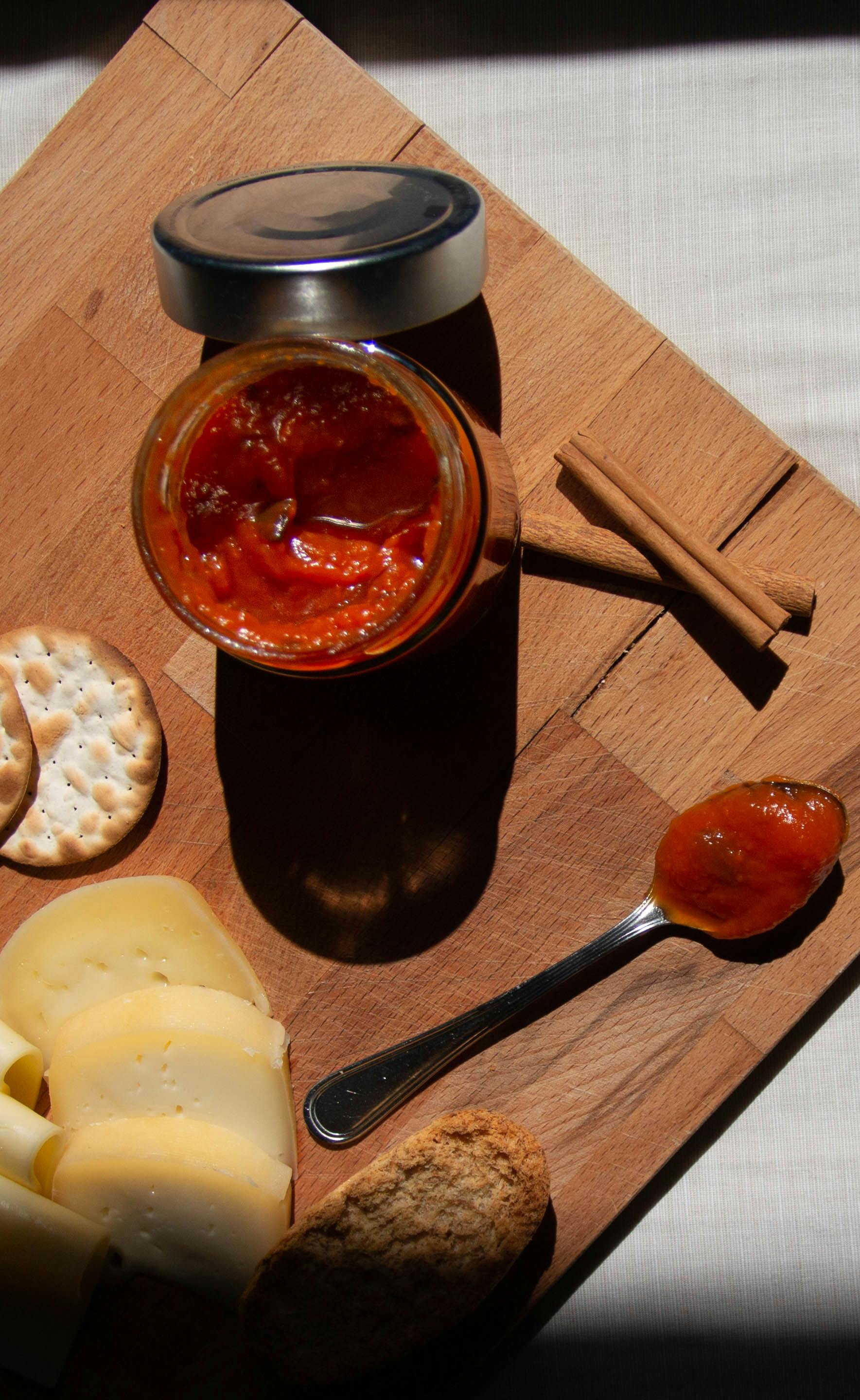 a cheese platter with jam on a jar