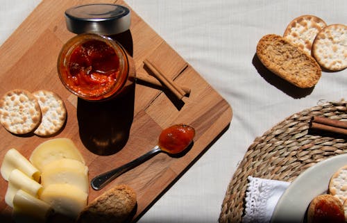 Red Sauce in a Glass Jar and on a Spoon on a Wooden Board