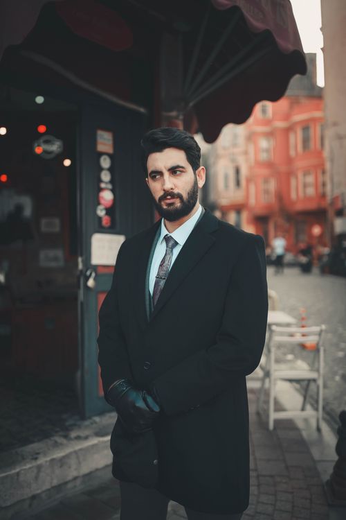 Free Elegant bearded man in a full suit with leather gloves on a city street. Stock Photo