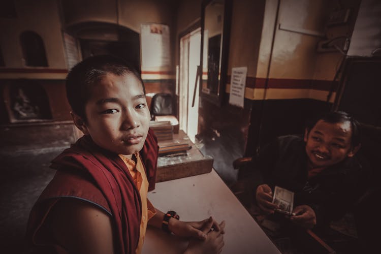 Asian Monk Teen And Man At Table In Church