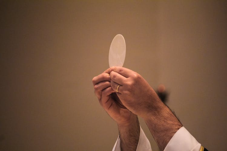 A Man Holding A Communion Host