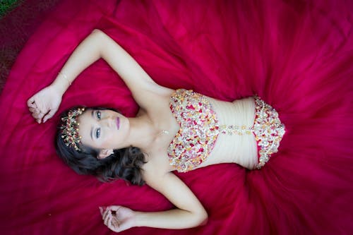 Free A Woman Lying Down Wearing a Red Gown Stock Photo