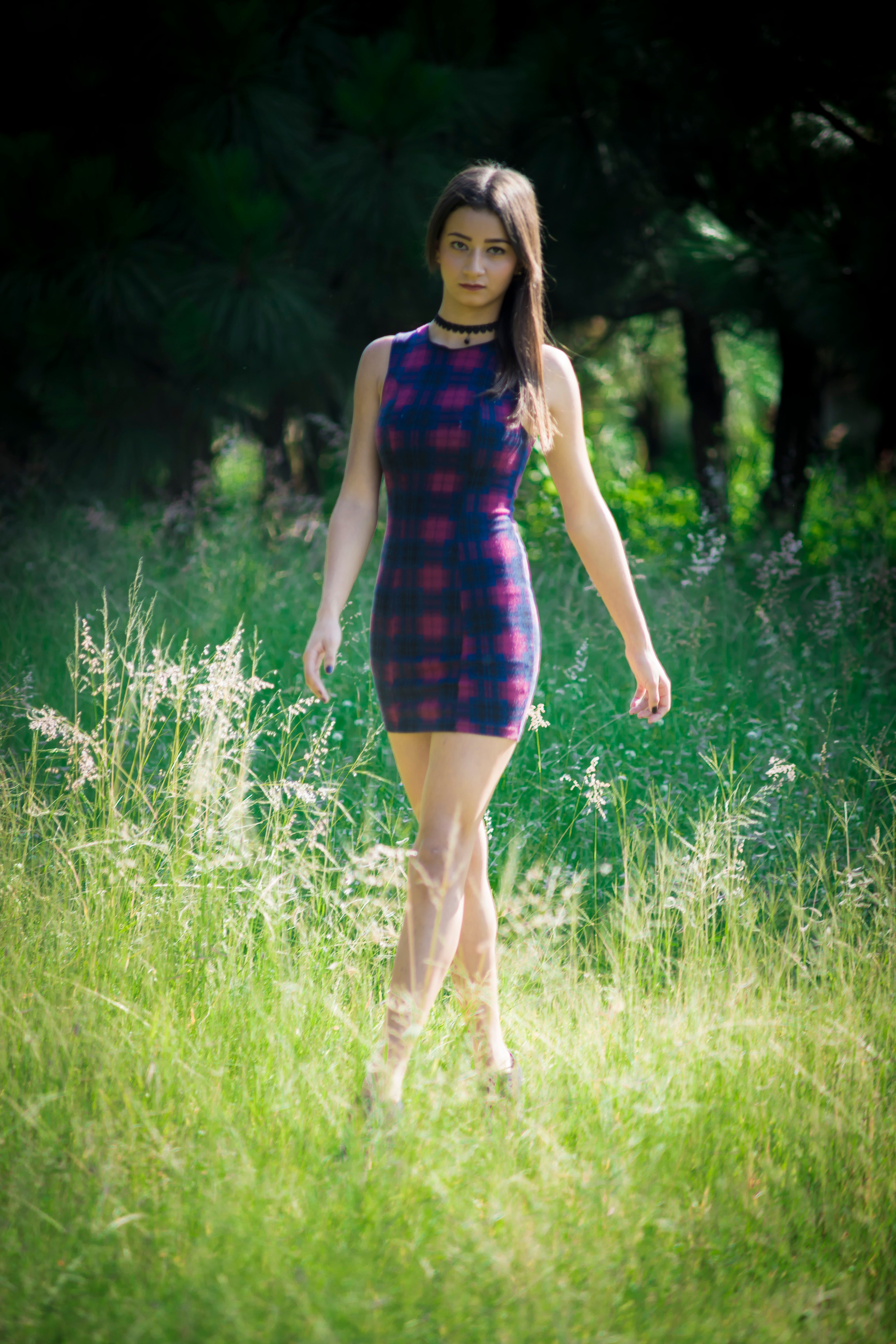 A Woman Walking on a Grass Field · Free Stock Photo
