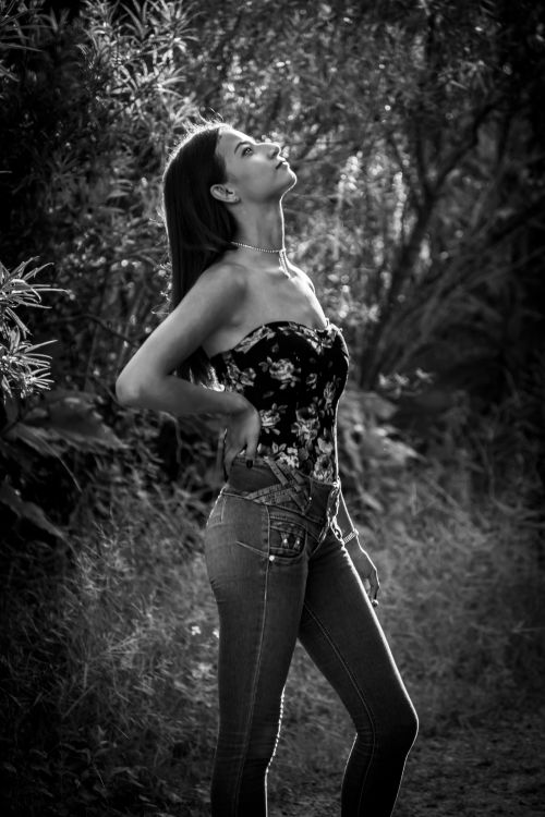 Free Elegant black and white portrait of a woman looking up in a natural setting. Stock Photo
