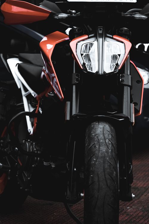 Free Front view of a sleek orange sport motorcycle parked indoors, showcasing its design and detail. Stock Photo