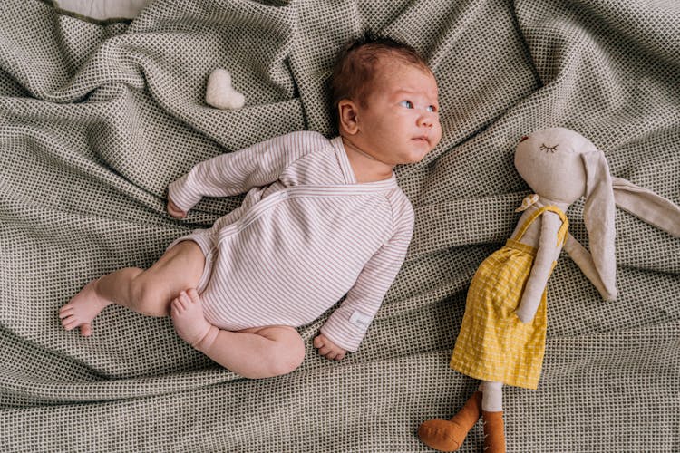 A Baby Lying Beside A Stuffed Toy 