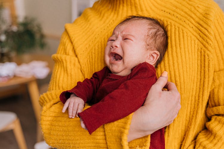 A Person Carrying A Crying Baby 