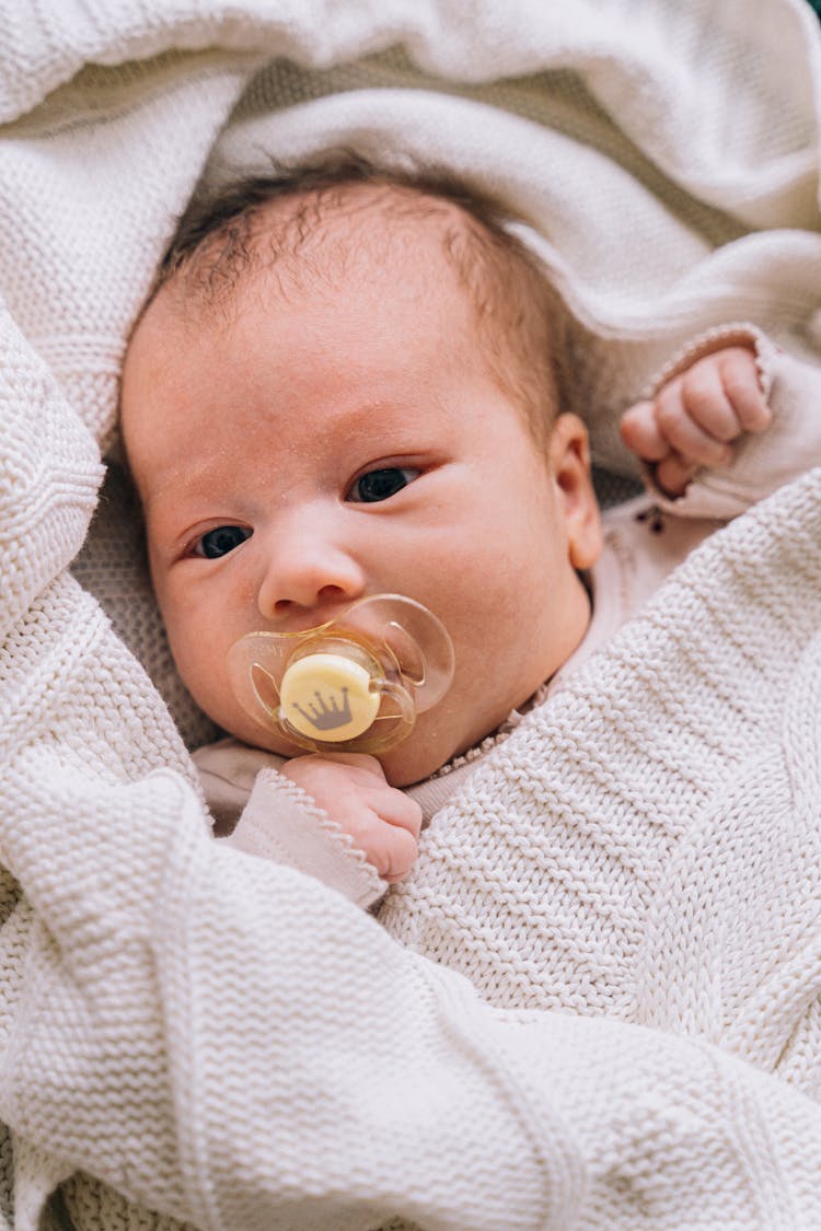 A Baby With A Pacifier 