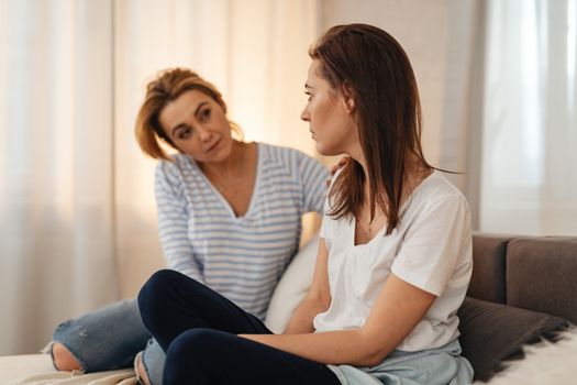 Mother and Grownup Daughter on Couch Talking 