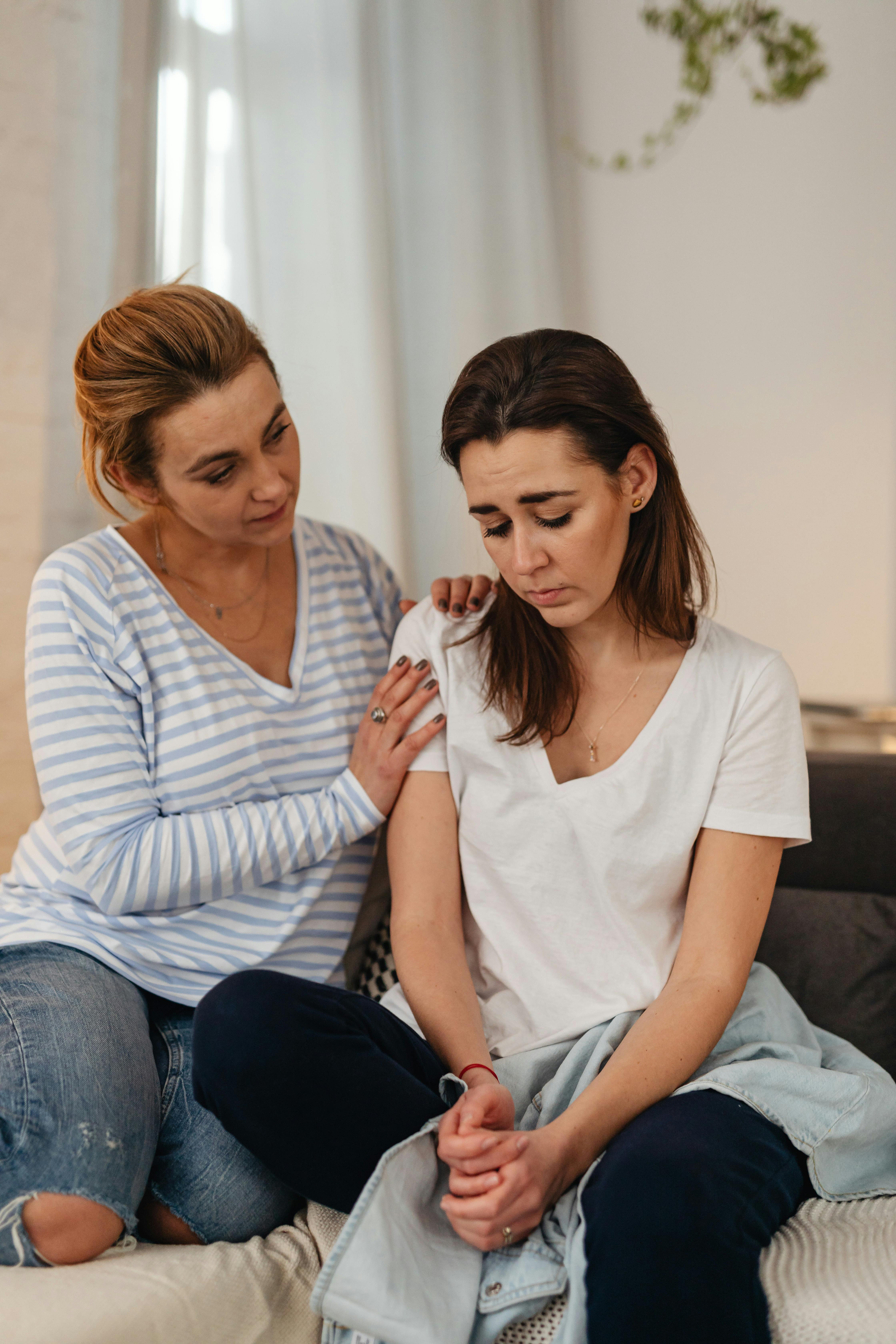 mother comforting sad daughter