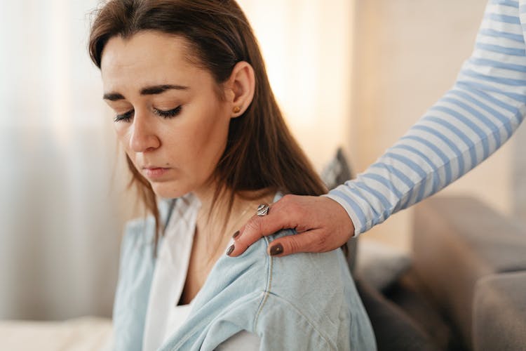 A Person Tapping A Woman's Shoulder