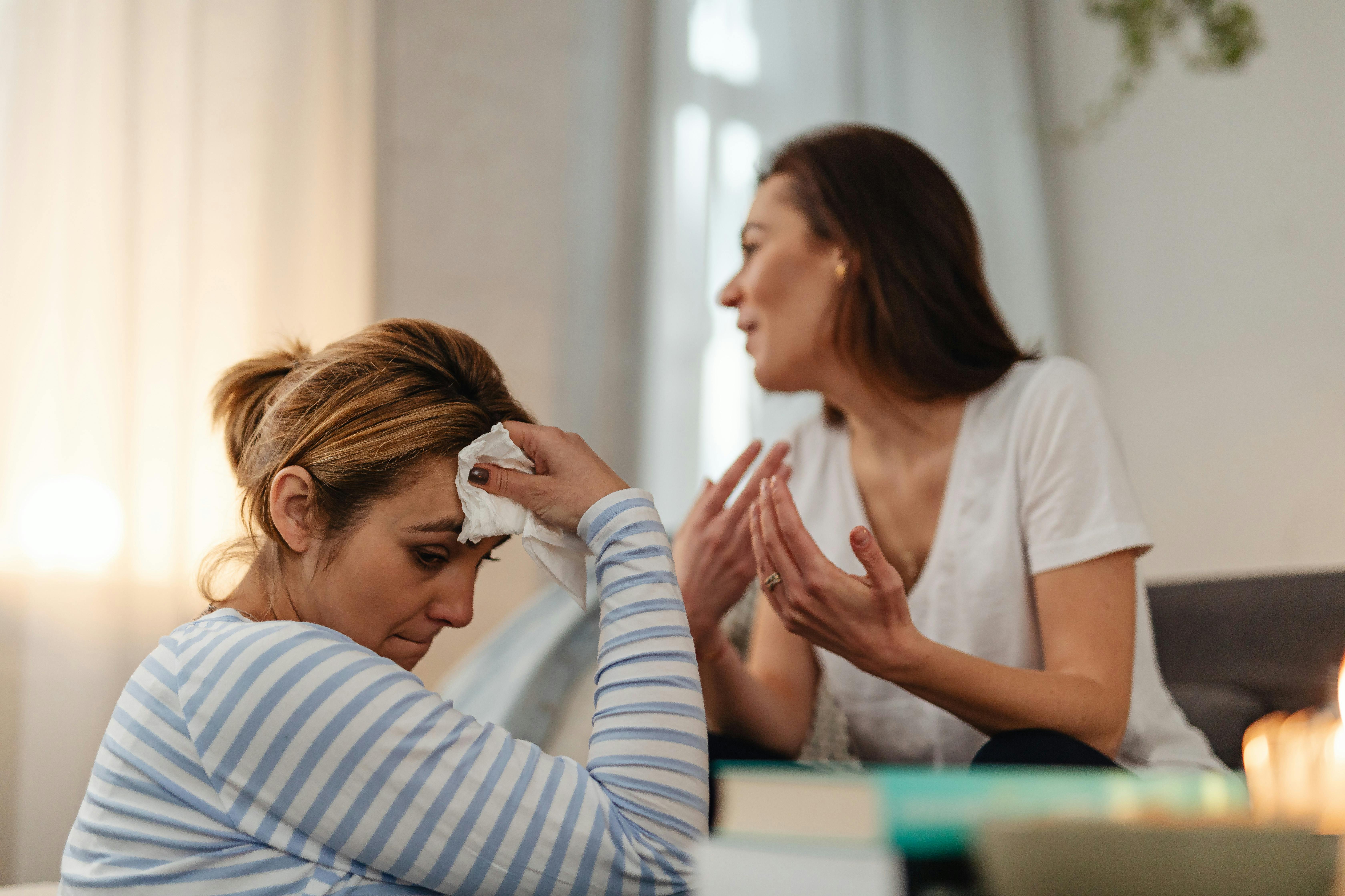 Two women in a tense, unresolved conversation, one looking away, the other with a concerned expression. - mother and daughter relationship