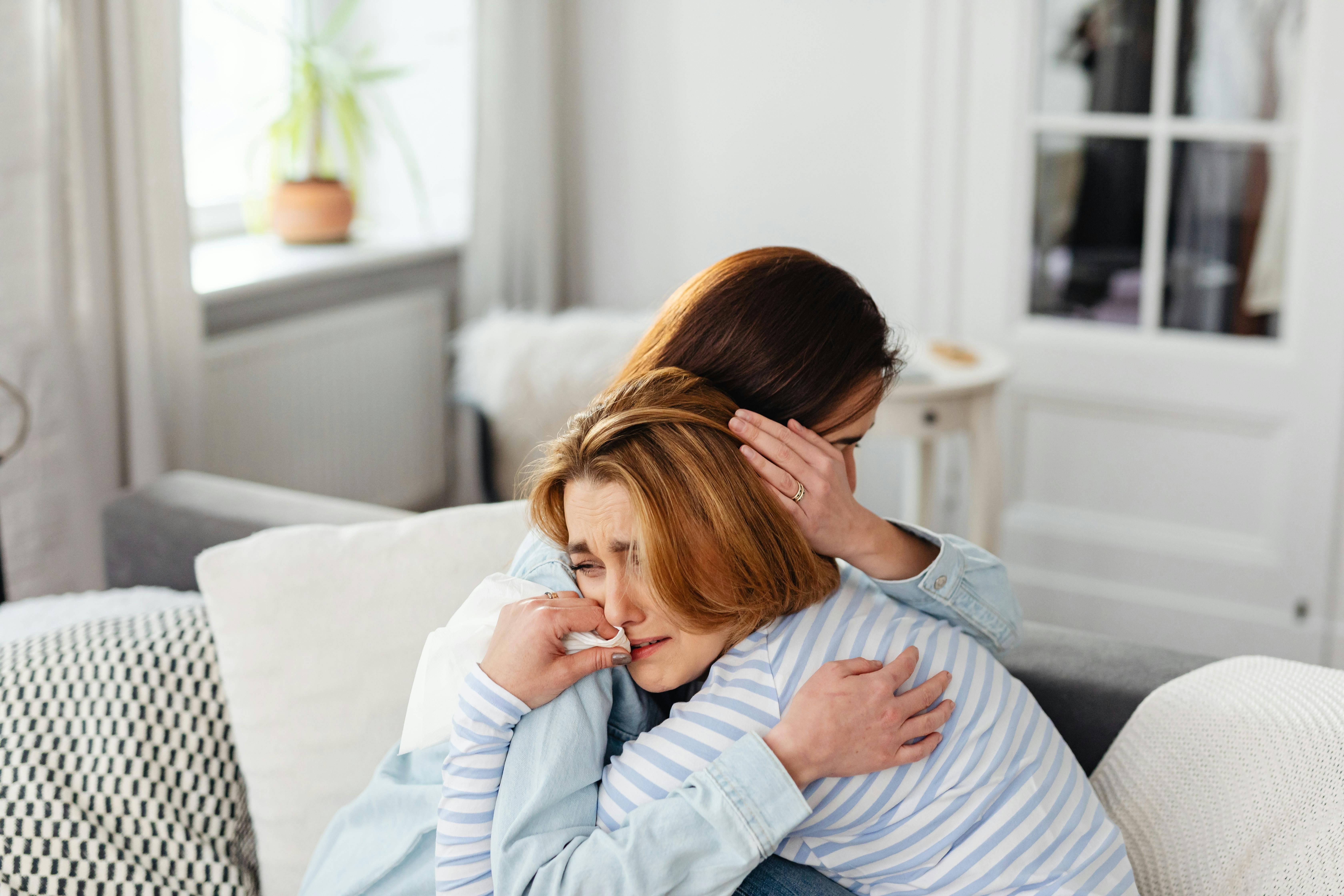 Photo of a Woman Hugging a Crying Woman