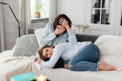 Photo of a Woman in a Striped Top Crying with Another Woman