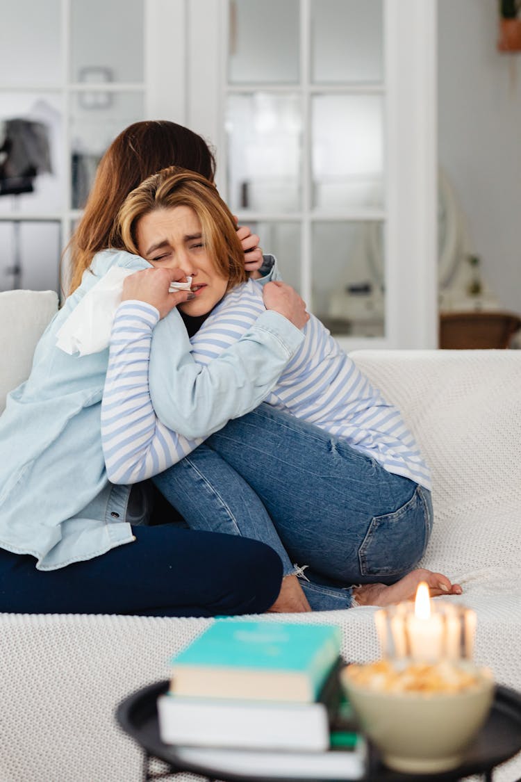 Sad Women Hugging On A Couch