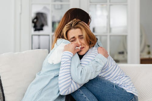 Free Sad Women Hugging on a Couch Stock Photo