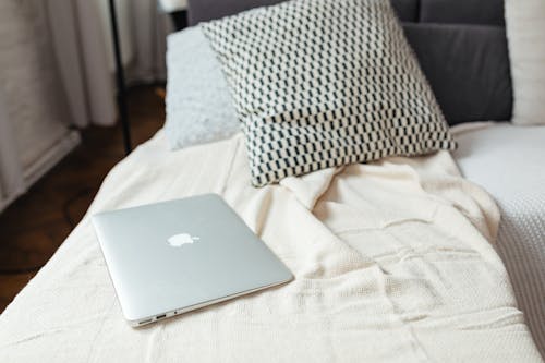 Free Close-Up Shot of a Silver Macbook on a Bed Stock Photo