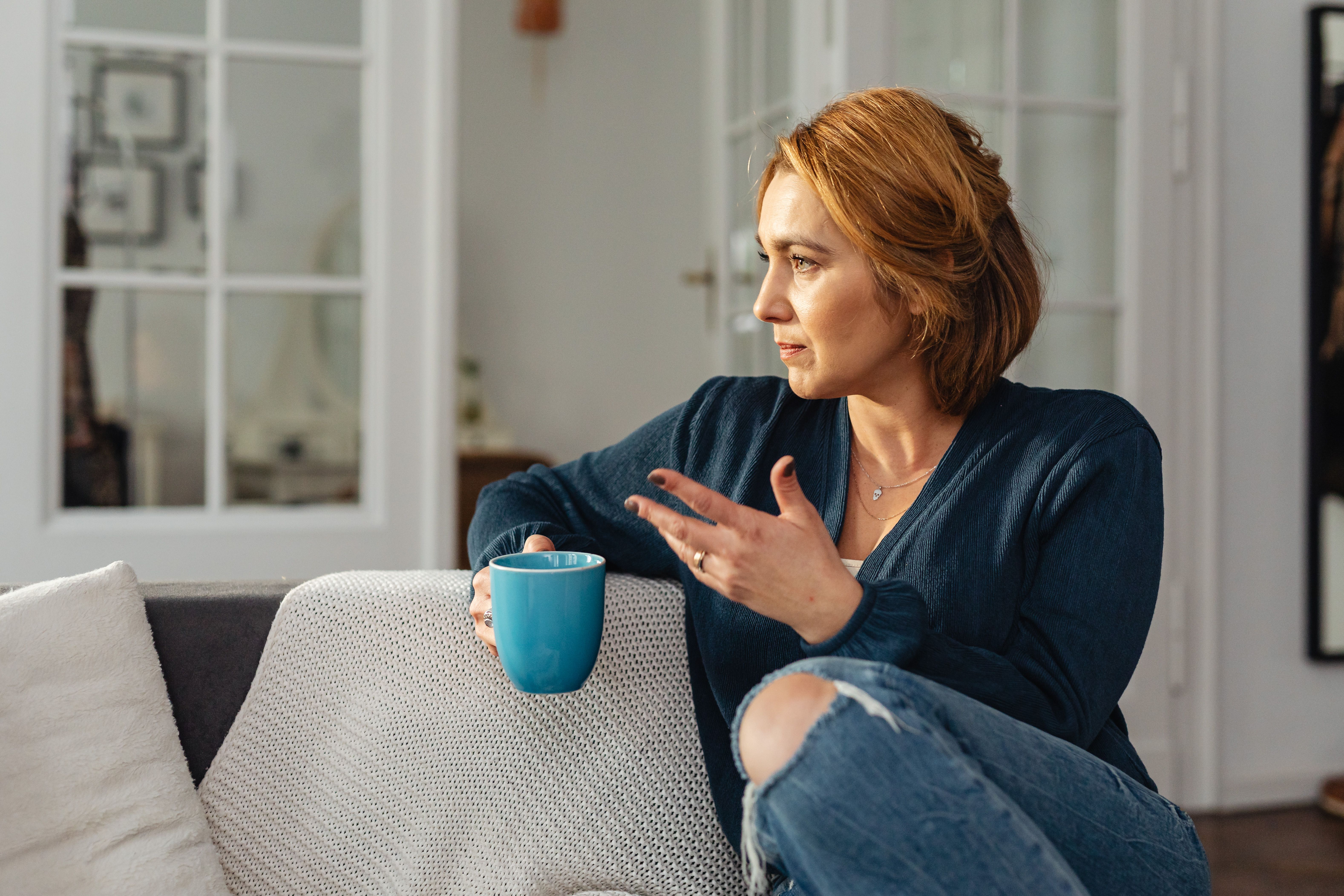 Woman Sitting on Couch with Cup of Coffee · Free Stock Photo
