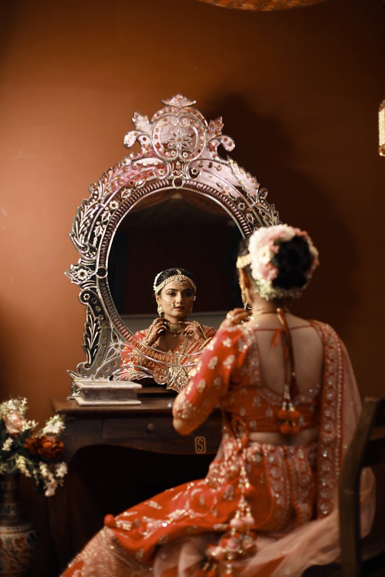 Woman Sitting In Front Of A Vanity Mirror