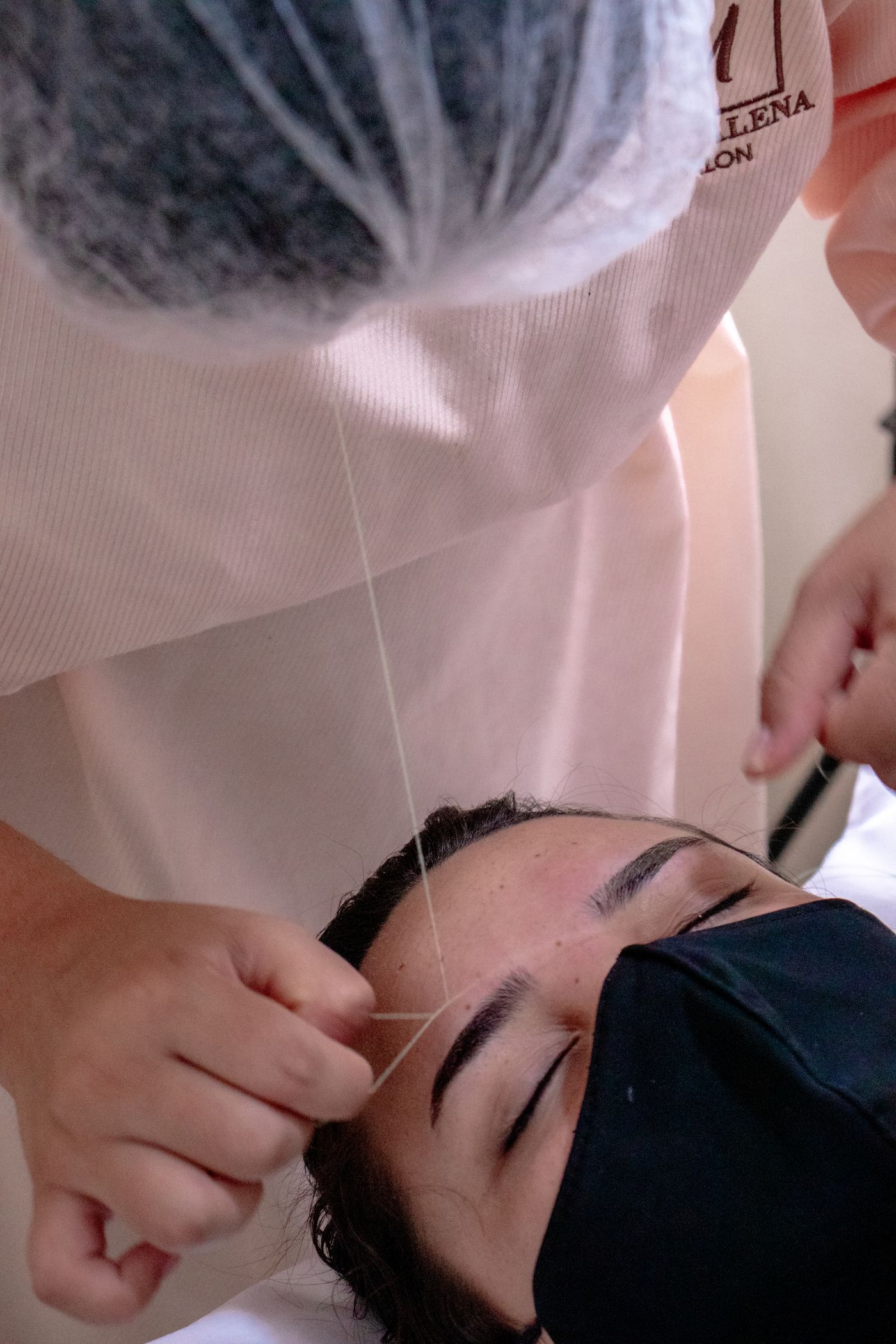 Close-up of eyebrow threading procedure at the salon