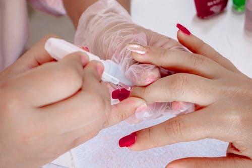 A Person Applying Nail Polish on a Fingernail 