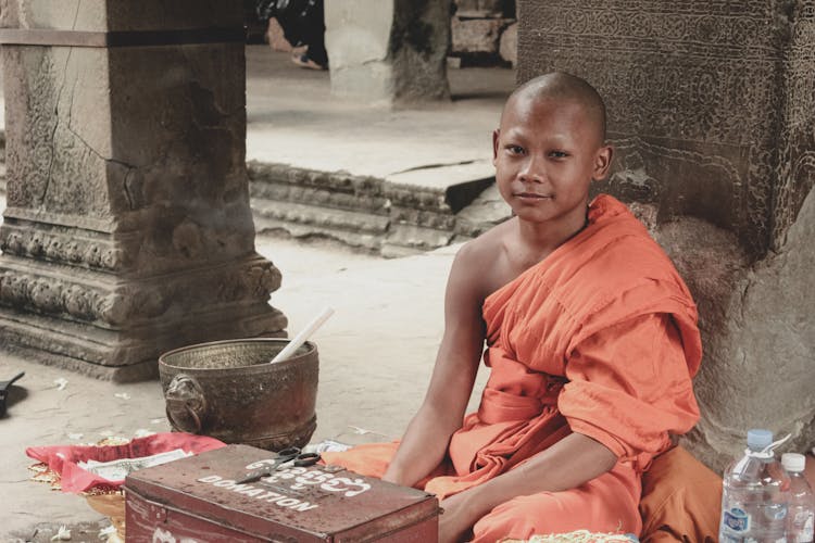 Small Monk Outside Buddhist Monastery