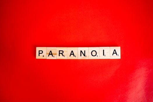 Scrabble tiles spell 'Paranoia' against a bold red background.