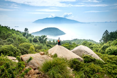 Free Unrecognizable traveler on stone against sea Stock Photo