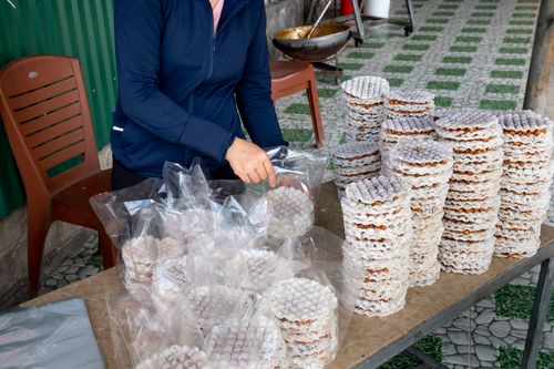 Free Crop unrecognizable female seller putting rice cakes with filling and chia seeds in plastic packs at desk Stock Photo