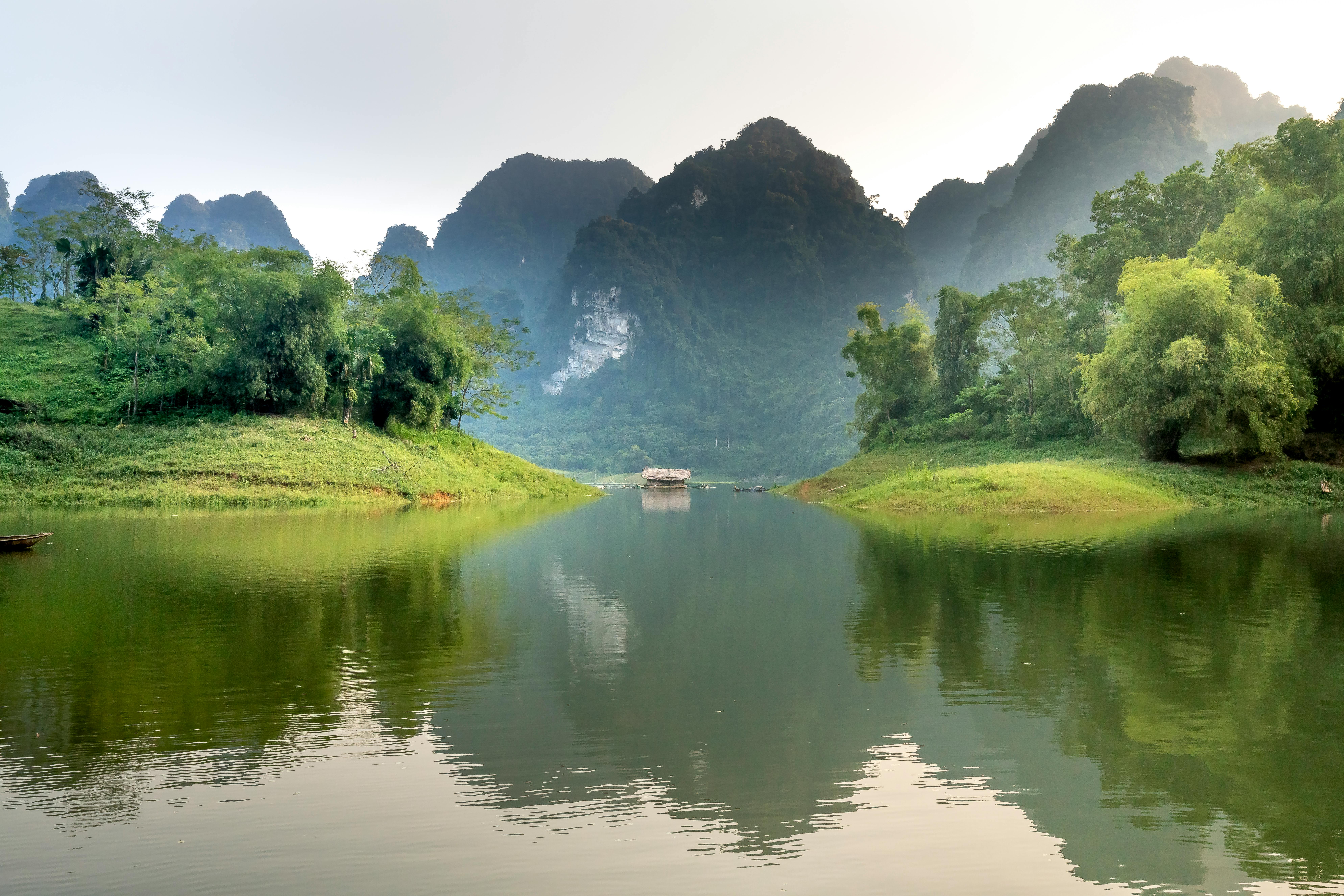 Tranquil landscape of Vietnam's limestone mountains and serene lake.