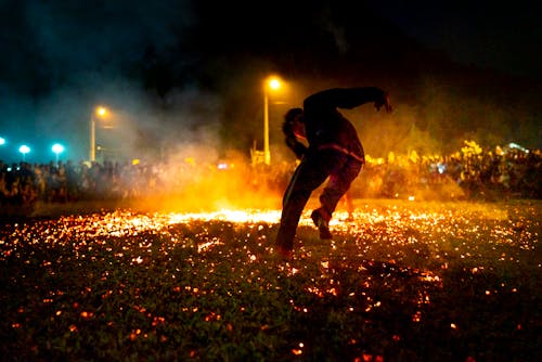 Man dancing in fiery sparks to crowd of people