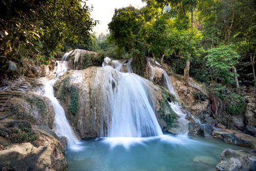 Free Picturesque view of pure pond against mount with foamy cascade and green trees in summer Stock Photo