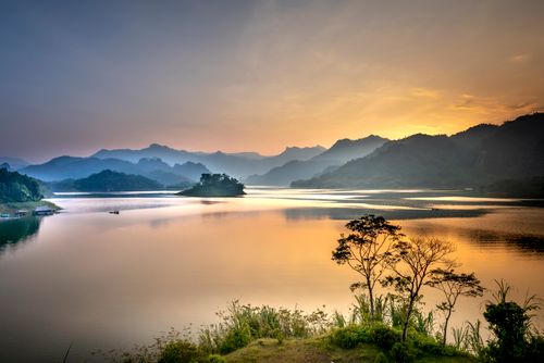 Free Spectacular view of rippled river against high ridge silhouettes in mist under colorful sky at sundown Stock Photo